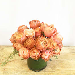 Peach roses arranged in a green vase