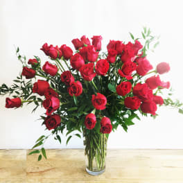 Red roses arranged in a clear glass vase