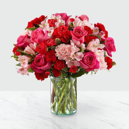 Pink and red mixed flower bouquet in a clear glass vase