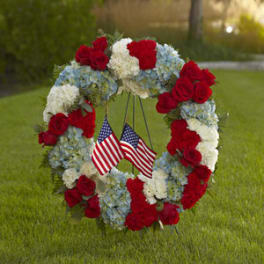 Red, white, and blue floral wreath with small American flags