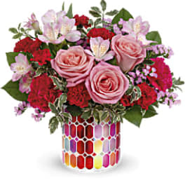 Pink roses and red carnations in a colorful mosaic vase