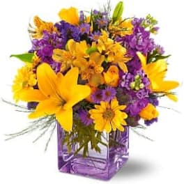Yellow and purple mixed bouquet in a purple glass vase