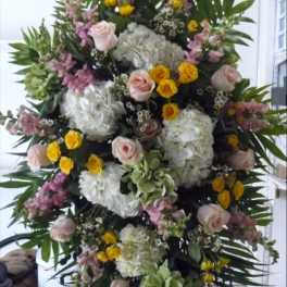 Large standing floral spray with pink roses, white hydrangeas, and yellow blooms