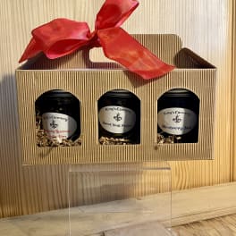 Gift box with three jars and a red ribbon bow