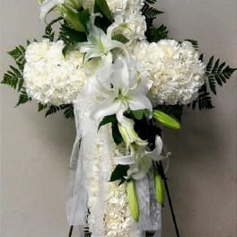 White funeral spray with lilies and carnations on a stand