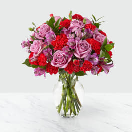 Pink roses and red carnations in a clear glass vase