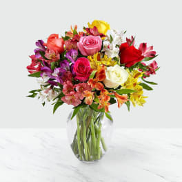 Mixed bouquet of roses and alstroemeria in a clear glass vase