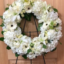 White floral wreath on a black stand
