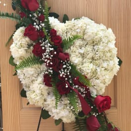Heart-shaped floral wreath with red roses and white hydrangeas