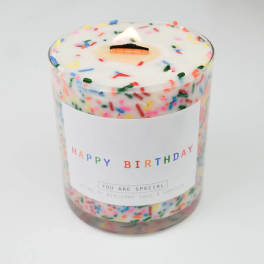 Birthday candle in a clear glass jar with colorful sprinkles