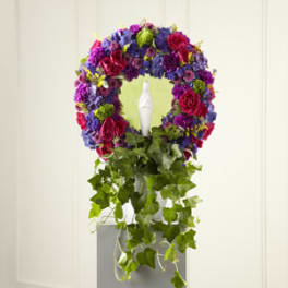 Colorful floral wreath with a white candle in the center and trailing ivy