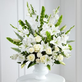 White lilies and roses arranged in a white vase