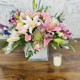 Pink and white mixed flower arrangement in a square glass vase