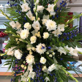 Large standing floral spray with white flowers and blue accents