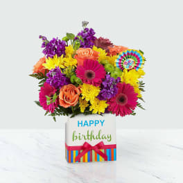 Colorful bouquet in a birthday gift box with a Happy Birthday tag