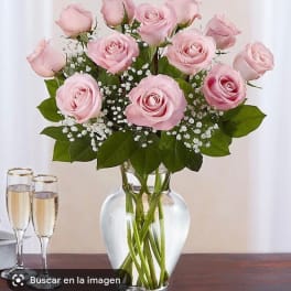 Pink roses arranged in a clear glass vase with baby's breath