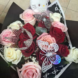 Bouquet of pink, red, and white roses with a plush cat topper