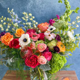 Mixed bouquet of colorful flowers in a glass vase on a table
