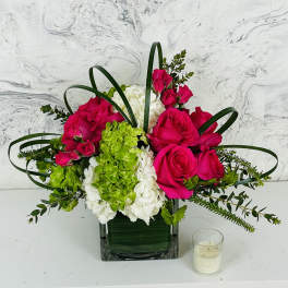 Pink roses and green-white hydrangeas in a square glass vase