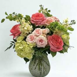 Pink roses and green hydrangeas in a textured glass vase