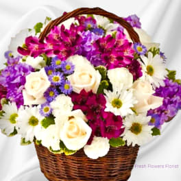 Basket of white roses, daisies, and purple flowers
