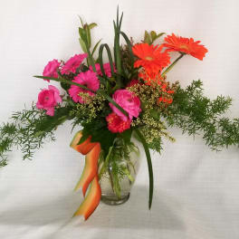 Pink and orange mixed bouquet in a clear glass vase