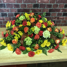 Colorful floral arrangement with roses, carnations, and mums on a table