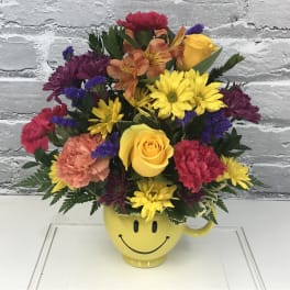 Colorful mixed bouquet in a yellow smiley-face mug