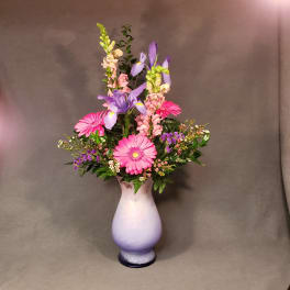 Pink and purple mixed flower arrangement in a lavender vase