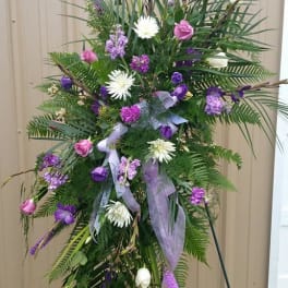 Tall standing floral spray with pink and purple flowers on a metal easel