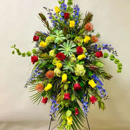 Large standing floral spray with red and yellow roses and blue flowers