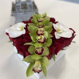 Heart-shaped bouquet of red roses with green and white orchids