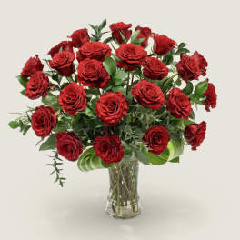 Red roses arranged in a clear glass vase