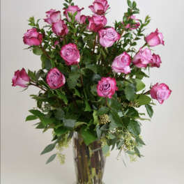 Tall bouquet of pink roses in a clear glass vase