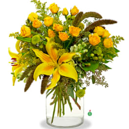 Yellow lilies and roses arranged with green accents in a clear glass cylinder vase