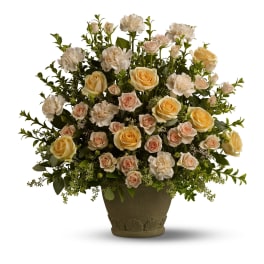 Large arrangement of cream and peach roses and carnations in a green textured pot