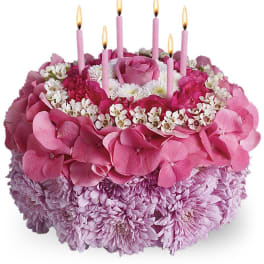 Pink floral cake with lit candles