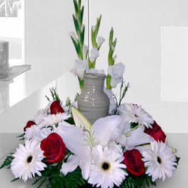 White and red floral arrangement in a gray vase
