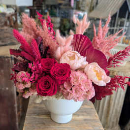 Pink and burgundy floral arrangement in a white vase