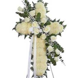 White floral standing cross with ribbon and greenery