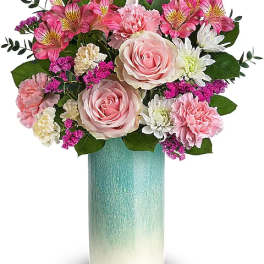 Pink and white flower arrangement in a tall turquoise vase
