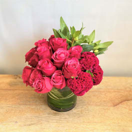 Pink roses and magenta cockscomb in a glass vase