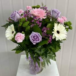 Bouquet of pink, lavender, and white flowers in a glass vase