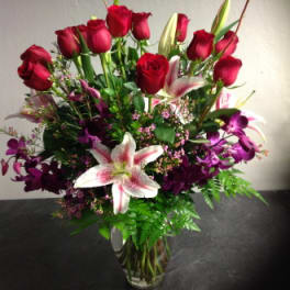Red roses and pink lilies in a clear glass vase