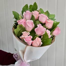 Bouquet of pink roses wrapped in white paper
