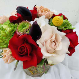 Bouquet of red, white, and peach flowers in a glass vase