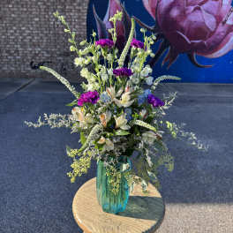Tall mixed bouquet in a teal glass vase with pink and white blooms