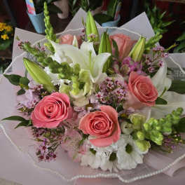 Bouquet of pink roses and white lilies with small purple flowers