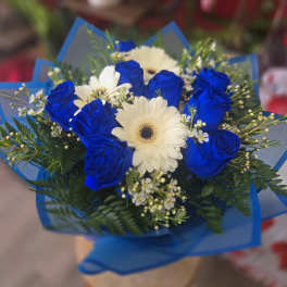 Bouquet of blue roses and white gerbera daisies wrapped in blue paper