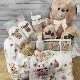Gift basket with teddy bear, slippers, mug, and blankets
